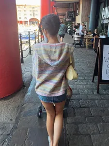 Back view of a colorful rainbow striped hooded knit cardigan showing casual fit and hood detail