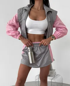 Detail of pink and grey color-block tracksuit set featuring zip-up jacket and skirt