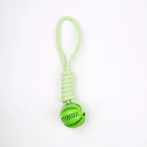 Detail view of a green rubber dog chew toy ball with durable woven rope for dental cleaning