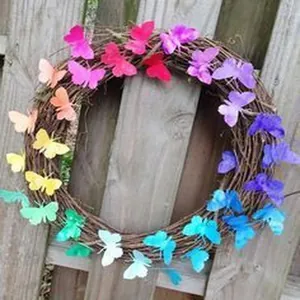 Primer plano de una corona de mariposas arcoíris en una valla de madera rústica
