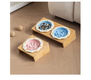 Dettaglio di ciotole slow feeder in ceramica su supporti inclinati in bambù per gatti.