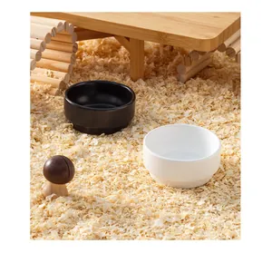 Gamelles en céramique noire et blanche pour hamsters dans un habitat naturel boisé