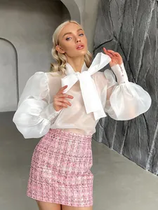 Primer plano de blusa francesa de malla blanca con lazo grande y mangas abullonadas