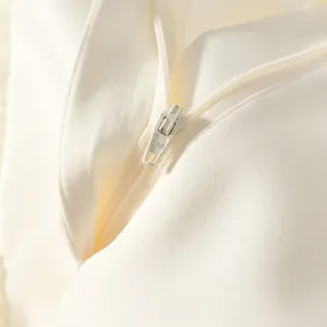 High-quality close-up detail showing the smooth white zipper and premium fabric texture