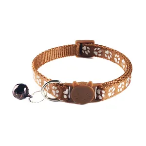 Detail van bruine kattenhalsband met pootafdrukken en katvormige gesp.