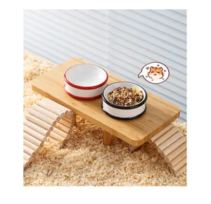 Vue détaillée des gamelles en céramique pour hamster sur plateforme en bois avec copeaux