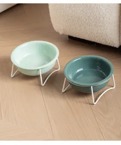 Paire de bols pour animaux en céramique avec supports en métal blanc dans un intérieur cosy.