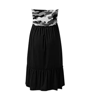 Detail view of strapless camouflage smocked dress with black ruffled skirt hemline