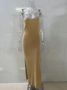 Full view of a gold knitted backless camisole dress with a side slit on mannequin