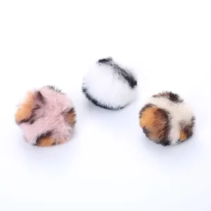 Three assorted patterns of soft fluffy plush cat toy fur balls on white background