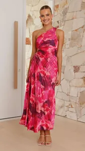 Detail view of a vibrant pink floral one-shoulder pleated maxi dress with waist cutout detail