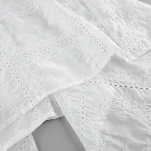 Gros plan détaillé sur la broderie florale blanche et la texture du tissu dentelle