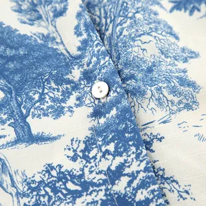 Close-up detail of blue tree print on white linen-textured fabric with button