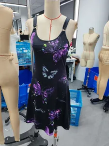 Foto real de un vestido negro de tirantes con vibrantes estampados de mariposas 3D.