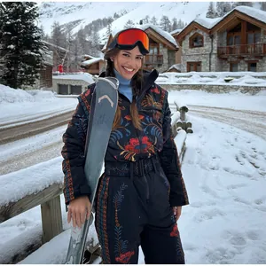 Detailed view of women's vintage floral embroidered ski jumpsuit in snowy resort