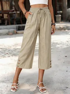 Detailansicht der khakifarbenen Damen-Caprihose mit Kordelzug und Zierknöpfen am Saum.