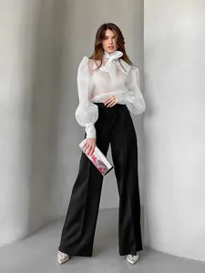 Detalle de la elegante blusa de malla blanca francesa con lazo y mangas abullonadas