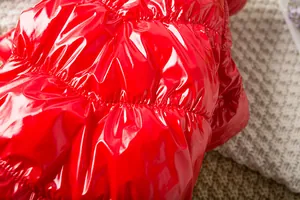 Dettaglio macro del tessuto rosso lucido resistente all'acqua della tuta per cani