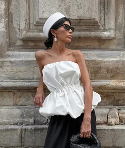 Close-up view of chic white strapless peplum tube top with gathered waist detail