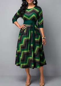Detail of a women's green and black chevron print midi dress with high waist tie belt.