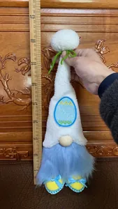 Detailopname van een handgemaakte paaskabouter pluche pop gemeten met een houten liniaal