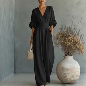 Elegant black V-neck jumpsuit with a cinched waist and wide-leg silhouette.