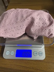 Digital scale measurement showing the 100.5g weight of this pink knit T-shirt