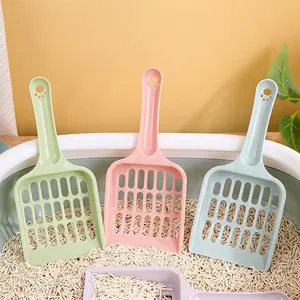 Set of macaron colored mesh cat litter scoops displayed inside a tofu litter box environment
