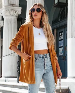 Detailed view of women's ochre velvet coat with soft texture and loose fit design