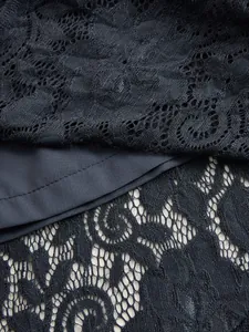 Close-up of vintage bohemian black lace fabric detail for a sleeveless midi dress texture.