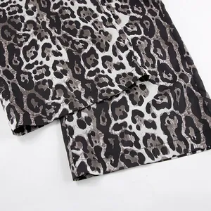 Close-up detail of stylish leopard print high-waisted wide-leg trousers showing hem stitching.