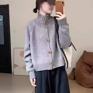 Detalle de un cárdigan de punto gris para mujer con cuello alto y botones de madera