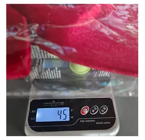 Close-up showing the 45g weight measurement of a red Christmas ribbon bow on a scale