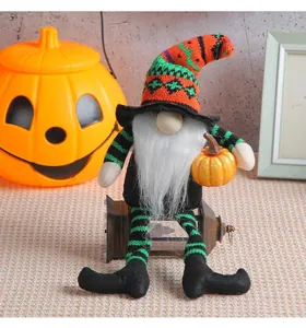 Detail of a Halloween gnome doll with striped legs holding a small pumpkin for decor