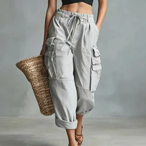 Detail of high street cargo pants for women with functional side pockets and drawstring waist.