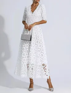 Detail view of a white V-neck lace evening dress with floral cutout patterns on model
