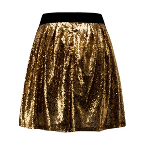 Dettaglio ravvicinato della texture scintillante della gonna a pieghe dorata donna.