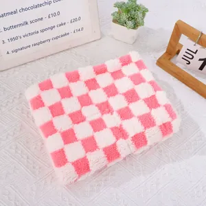 Κοντινή λήψη μιας μαλακής ροζ και λευκής καρό βελούδινης κουβέρτας για σκύλους και γάτες