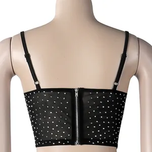 Detalle de la espalda de un crop top negro con pedrería y cierre de cremallera plateada.