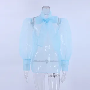 Blusa de malla azul claro transparente con lazo grande en el cuello y mangas abullonadas.