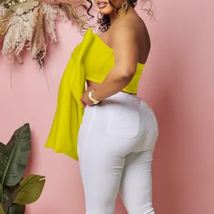 Vista dettagliata del crop top giallo senza spalline con decoro a grande fiocco