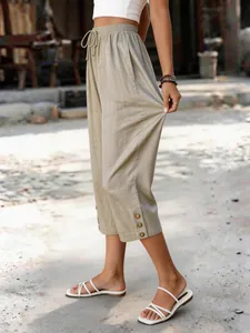 Detailansicht der lässigen Caprihose für Damen mit dekorativen Knöpfen am Saum.