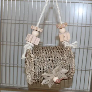 Detailed view of the woven straw hanging parrot nest with wooden bead accents
