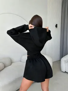 Vista trasera de un conjunto de sudadera corta con capucha y pantalones cortos negros