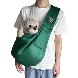 Close-up of a breathable green mesh pet sling bag worn as a crossbody shoulder carrier.