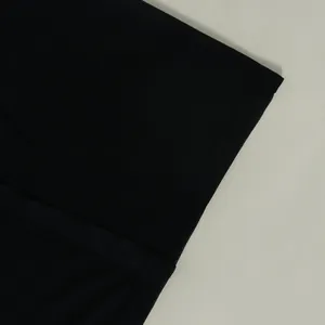 Detailed view of the black ribbed fabric and fine stitching on the sleeve edge