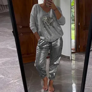 Detailed view of women's two-piece set featuring silver metallic pants and printed top