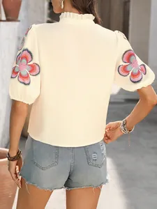 Back view of a stylish cream puff sleeve blouse with colorful floral embroidery detail.