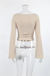Détail de la taille plissée à l'arrière d'un haut en maille côtelée beige à manches longues.
