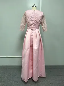 Vue arrière d'une robe de soirée rose en dentelle avec traîne sur un mannequin de couture.